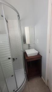 y baño con lavabo y ducha con espejo. en Apartamento Estocolmo III, en Valdivia
