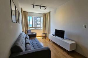 uma sala de estar com um sofá e uma televisão de ecrã plano em Apartamento moderno em excelente localização em Bento Gonçalves