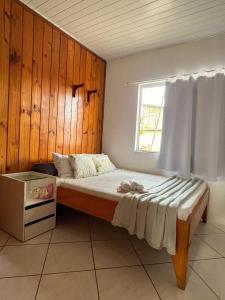 a bedroom with a large bed with a window at Espaço caraguatá in Florianópolis