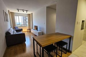 uma sala de estar com uma mesa e um sofá em Apartamento moderno em excelente localização em Bento Gonçalves