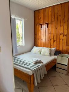 a bed with a wooden headboard and a window at Espaço caraguatá in Florianópolis