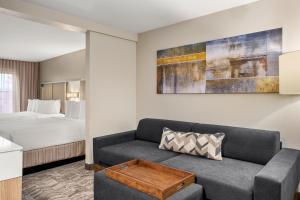 sala de estar con sofá y cama en SpringHill Suites by Marriott Chicago Bolingbrook, en Bolingbrook