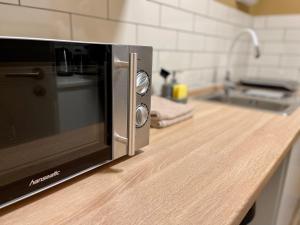 a microwave oven on a counter in a kitchen at Terracotta Apartment - Zentral, Parken, Netflix, Kontaktloses Einchecken, Kingsize-Bett in Wuppertal