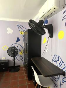 a room with a desk with a car tire hanging from a ceiling at Hostal Casa Macondo in Santa Marta