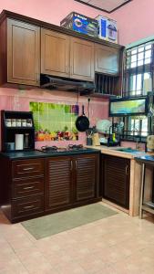 a kitchen with wooden cabinets and a counter top at AF HOMESTAY in Dungun