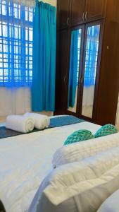 a bedroom with two beds with blue curtains at AF HOMESTAY in Dungun