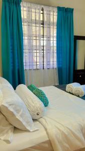 a large bed with blue curtains and pillows on it at AF HOMESTAY in Dungun