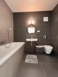 a bathroom with a tub and a sink and a toilet at AR ALBELLI HOUSE in Košice +9 photos