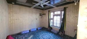um quarto vazio com uma ventoinha de tecto e uma janela em POP Home Zohan Homestay em Jamu