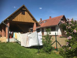 una casa con ropa colgada en una línea de ropa en Csörgő Vendégházak, en Szalafő