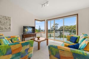 a living room with two couches and a television at Daybreak by Experience Jervis Bay in Vincentia