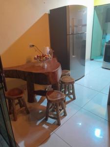 a kitchen with a wooden table and some stools at Recanto Alto da Serra 