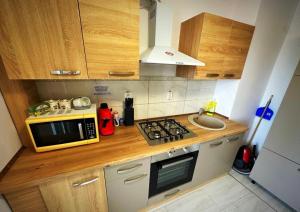 a small kitchen with a microwave and a sink at Apartament cu 2 dormitoare decomandat/Utilat acceptam plata cu cardul oferim factura in Botoşani
