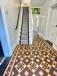 a hallway with a staircase with a tiled floor at Historic Charm: *Perfect For Group Getaways* in Trowbridge +51 photos