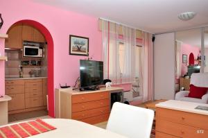 斯普利特的住宿－Apartment BM ST2，客厅设有粉红色的墙壁和电视。