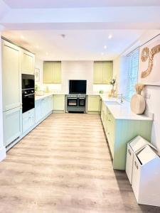 a large kitchen with blue cabinets and white appliances at Historic Charm: *Perfect For Group Getaways* in Trowbridge