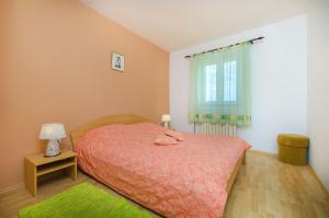 a small bedroom with a bed and a window at House Andelka in Supetar