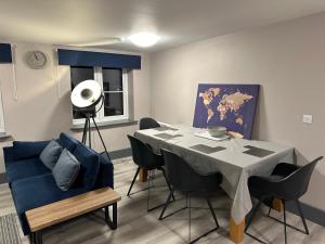 a dining room with a table and a blue couch at NEW HAVEN APARTMENTS IN THE CENTRE. in Boston