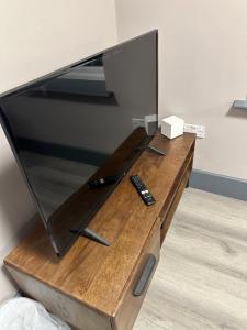 een flatscreen-tv op een houten tafel bij NEW HAVEN APARTMENTS IN THE CENTRE. in Boston