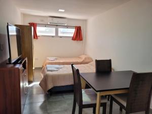 a small room with a table and a dining room at Apart Mi Kaú in Catriel