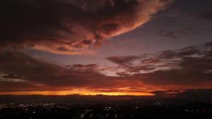 un coucher de soleil sur une ville avec un ciel nuageux dans l'établissement Xandari Resort & Spa, à Alajuela