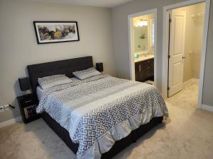 Brand New-Budget friendly master bedroom-House في Carleton Place: غرفة نوم بسرير كبير وحمام