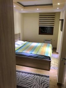 een slaapkamer met een bed met een regenboog deken bij Apartment Elvir in Kopaonik