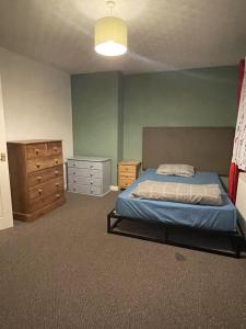 a bedroom with a bed and a dresser at Inviting 2-Bed House in Birmingham in Birmingham