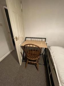 a small room with a wooden table next to a bed at Inviting 2-Bed House in Birmingham in Birmingham