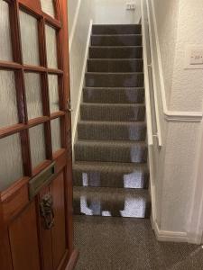 a view of a staircase with a cat sitting next to a door at Inviting 2-Bed House in Birmingham in Birmingham