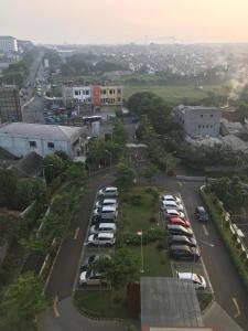 una vista aérea de un aparcamiento con coches aparcados en Jasmin Park Apartemen By Fix's Room, en Kedungbadak
