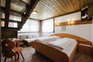 a bedroom with two beds and a chair at Apartments Roda de Ciar in Badia
