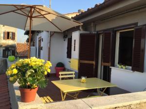 een gele tafel en een parasol op een patio bij L'Attichetto di Zagarolo in Zagarolo