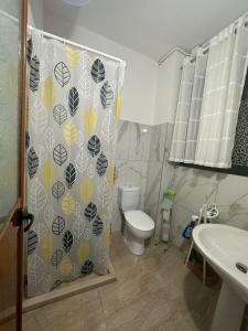 a bathroom with a toilet and a shower curtain at Kleidi's home in Vlorë