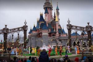 una multitud de personas de pie en frente de un castillo en Disneylodge, en Chessy