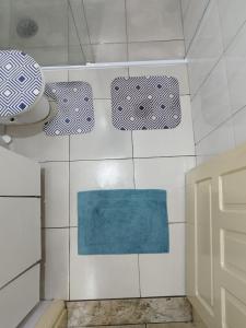 a bathroom with white tiles and a blue rug at Casa da Vila Hostel Guest House in São Paulo