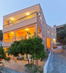 a large apartment building with a tree in front of it at Apartments Branka in Podgora