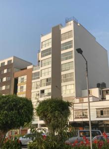 ein hohes Gebäude mit davor geparkt in der Unterkunft Edificio parque residencial in Lima