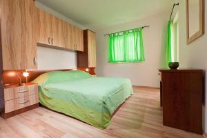 1 dormitorio con cama y ventana verde en Apartments Branka, en Podgora