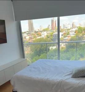 1 dormitorio con cama blanca y ventana grande en Villa Ángela en Posadas