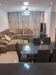 ein Wohnzimmer mit einem Sofa und einem Tisch in der Unterkunft Edificio parque residencial in Lima