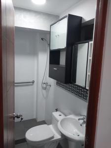 ein weißes Bad mit einem WC und einem Waschbecken in der Unterkunft Edificio parque residencial in Lima