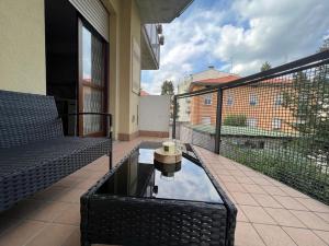een balkon met een tafel en een zwembad met water bij Berghome in Bergamo