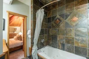 a bathroom with a tub and a bedroom at Rainbow Lodge by Outpost Whistler in Whistler +64 photos
