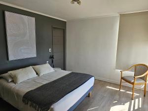 a bedroom with a bed and a chair at Espectacular Bahía Bonita depto 32 in Concón +3 photos