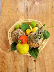 a basket of fruits and vegetables on a wooden table at Naraha Beach House in Kidenga