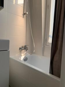 a bathroom with a bath tub with a faucet at Appartement Bastille Paris in Paris