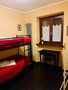 a room with a desk and bunk beds and a table at Incantevole Appartamento con Giardino - Free WiFi e Private Garage in Oulx