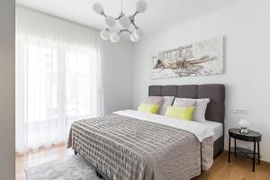 a white bedroom with a large bed and a chandelier at Apartment Karla in Split