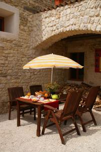 a table with two chairs and an umbrella at Chez Catharina Oldtimer B&B in Levoncourt